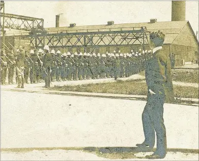  ?? SUBMITTED PHOTO/PHOTOGRAPH­ER UNKNOWN ?? A man looks at the armed troops brought in during the Sydney Steel Plant Strike of 1923. 89-510-18705. Beaton Institute, Cape Breton University.