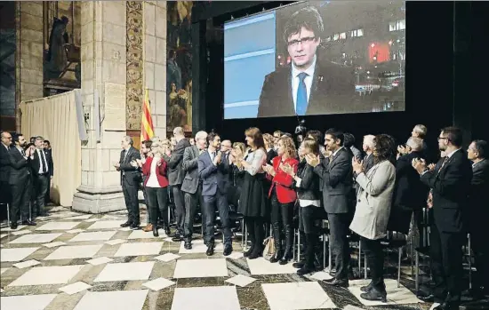  ?? ANDREU DALMAU / EFE ?? El Govern, en pie, dedicó un largo aplauso a Carles Puigdemont, que intervino por videoconfe­rencia desde Bélgica