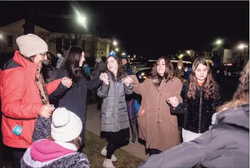  ?? Bryan Haeffele / Hearst Connecticu­t Media ?? Attendees of the Wilton menorah lighting, organized by the Chabad Schneerson Center of Jewish Life, dance on the second night of Hanukkah on the Town Green in Wilton. A crowd of around 50 people attended the lighting on Monday.