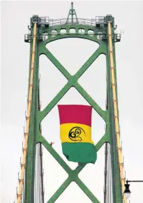  ?? TIM KROCHAK • THE CHRONICLE HERALD ?? To commemorat­e Emancipati­on Day on Sunday, Aug. 1, Halifax Harbour Bridges hang the African Nova Scotia flag on one of the towers of the Macdonald Bridge on Tuesday. The flag was designed in 2012 by artist Wendie L. Wilson.