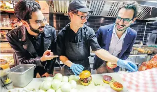  ?? JOHN MAHONEY ?? Burger Week founders Na’eem Adam, left, and Thierry Rassam flank Notre-Boeuf-de-Grâce cook Alex Rosette. Adam and Rassam claim to be conscious of their cholestero­l levels, but allow themselves two weeks a year to give in to their more gluttonous instincts, writes Bill Brownstein.