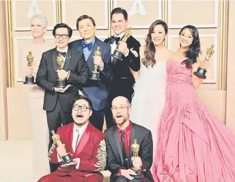  ?? — AFP photo ?? (From le ) The cast and crew of ‘Everything Everywhere All at Once’ Jamie Lee Curtis, Ke Huy Quan, James Hong, Jonathan Wang, Michelle Yeoh, Stephanie Hsu, Daniel Kwan (bo om le ), and Daniel Scheinert (bo om right), pose with their Oscar trophies in the press room during the 95th Annual Academy Awards at the Dolby Theatre in Hollywood, California.