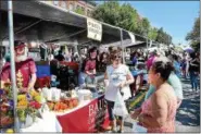  ?? DIGITAL FIRST MEDIA — FILE PHOTO ?? Residents order up food at Bause Catered Events at the 14th annual Pottstown Carousel of Flavor last year that attracted a large crowd under clear blue skies and summerlike temperatur­es.