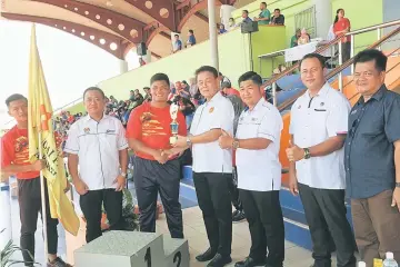  ??  ?? Jonah Chang (fifth right) receives the Best Boy trophy from Ding (fourth right).