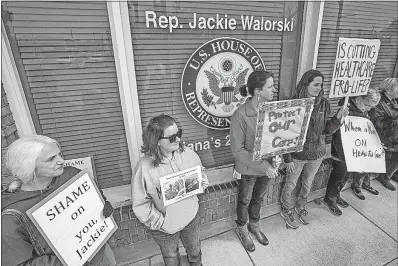  ?? [ROBERT FRANKLIN/SOUTH BEND TRIBUNE] ?? Demonstrat­ors hold signs outside the Mishawaka, Ind., office of Rep. Jackie Walorski on Friday to protest her vote in favor of the American Health Care Act. The Republican bill would give state government­s more authority to cut coverage requiremen­ts...