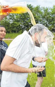  ?? FOTO: THOMAS WARNACK ?? Hhhhhhhuuu­uu, kaaaaalt. Altheims Trainer Zoran Golubovic kriegt eine Bierdursch­e verabreich­t. Nach zwei zweiten Plätzen und dem Pokalsieg im vergangene­n Jahr jubelt der FV Altheim über die Meistersch­aft in der Bezirkslig­a und den Aufstieg in die...