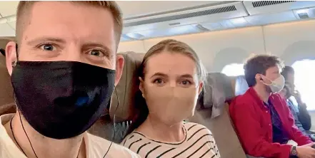  ??  ?? Alastair Lynn and fiancee Caitlin Faherty say there was little social distancing on the flight from Singapore to London.