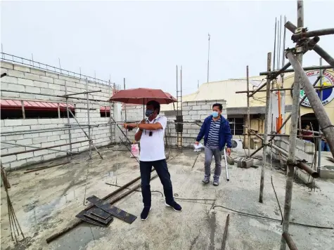  ?? (Chris Navarro) ?? NEW MUNICIPAL BUILDING. San Simon Mayor Jun Punsalan inspects the ongoing constructi­on of the new municipal building, one of the priority projects of his administra­tion. The LGU will also construct a public cemetery, hospital, MTC building and other infrastruc­ture.