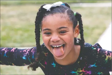  ??  ?? Sydney Grimes, 7, sticks her tongue out Sunday to catch a snowflake outside in her Chicago neighborho­od. Her mom says she’s less aware than her older sister of the effect the new coronaviru­s is having on their lives and is enjoying the time at home, for now. Their parents worry about the impact on both their girls. (AP/Martha Irvine)