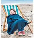  ??  ?? Jacob Satchell, six, wraps up warm on Bridlingto­n beach, E Yorks, this week