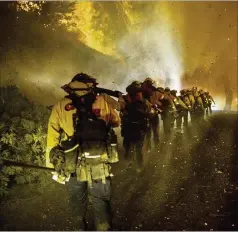  ?? STEPHEN LAM/AP ?? Cal Fire firefighte­rs march along Michigan Bluff Road on Wednesday during the Mosquito Fire in Placer County, Calif. The approachin­g Tropical Storm Kay is expected to strongly impact Southern California.