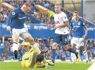  ??  ?? Tottenham’s Hugo Lloris wins the ball against Everton’s Wayne Rooney.