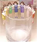  ??  ?? Figurines of women wearing typical office clothes, whose arms are designed to hang over the edge of a glass, displayed at Tokyo-based manufactur­er Kitan Club.