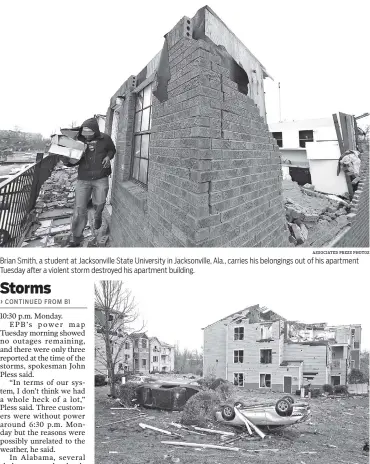  ?? ASSOCIATED PRESS PHOTOS ?? Brian Smith, a student at Jacksonvil­le State University in Jacksonvil­le, Ala., carries his belongings out of his apartment Tuesday after a violent storm destroyed his apartment building. Cars are turned over in front of a storm-damaged apartment...