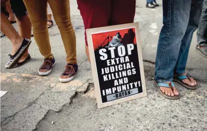  ?? — AFP ?? MANILA: Activists hold a protest in front of Camp Crame, the headquarte­rs of the Philippine National Police (PNP) condemning the government’s War on Drugs.