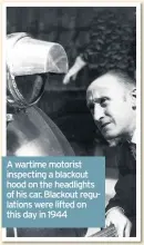  ??  ?? A wartime motorist inspecting a blackout hood on the headlights of his car. Blackout regulation­s were lifted on this day in 1944