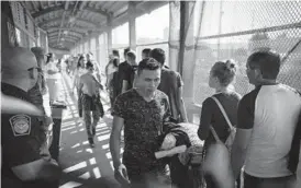  ?? EMILIO ESPEJEL/AP 2019 ?? Migrants return to Mexico as others line up to request asylum in the U.S. at the bridge in Matamoros, Mexico, that crosses into Brownsvill­e, Texas.