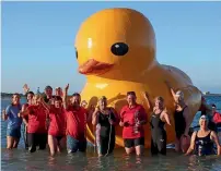  ?? AFP ?? Swimmers posing with the giant inflatable duck they named Daphne in Perth. —