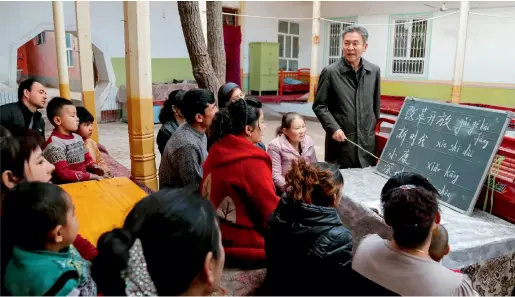  ??  ?? In Yuqarqi Kapa Village, Saybagh Township, Kona Sheher County, small classes are offered for villagers to learn the national language and writing by members of the team stationed in the Agricultur­al and Rural Department of Xinjiang Uygur Autonomous Region. Xie Long