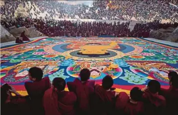  ?? AFP PIC ?? Tibetan Buddhist monks unveiling a giant thangka during Losar, the Tibetan new year, at the Rongwo Monastery in the Huangnan Tibetan Autonomous Prefecture, on the Qinghai-Tibet plateau, recently.