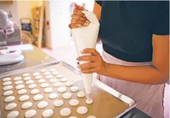  ??  ?? Chainé Peña works on her macarons Friday. ‘There’s a lot of thought in the details, and there’s a lot of intention, too,’ she said.