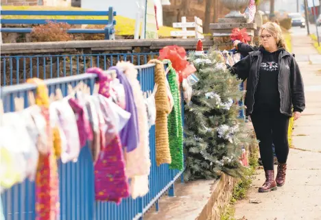  ?? TOTHE MORNING CALL PHOTOS BYRICH HUNDLEYIII/SPECIAL ?? Denise Martinez, of Slathingto­n, hangs scarves on the fence in front of the Springside Fire Company on Slatington’s Main Street as part of Project Warm and Cozy. Martinez started the project after she was forced to leave her job due to a medical condition.