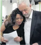  ??  ?? > Jeremy Corbyn comforts a local resident at St Clement’s Church in west London, where volunteers have provided shelter and support for people affected by the fire