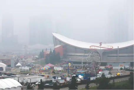  ?? GAVIN YOUNG ?? Smoke from wildfires blanketed Calgary on Sunday, obscuring the skyline beyond the Stampede grounds on the festival's final weekend.