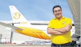  ??  ?? NokScoot chief executive Yodchai Sudhidhana­kul with a recently delivered Boeing 777-200.