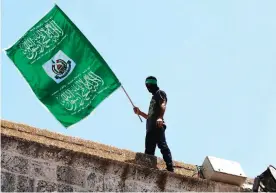  ??  ?? JERUSALEM: A Palestinia­n man waving the green flag of the Islamist movement Hamas during a demonstrat­ion outside the Dome of the Rock at the Al-Aqsa Mosque compound in Jerusalem. — AFP