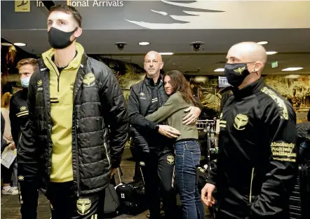  ?? ROSA WOODS/STUFF ?? Phoenix goalkeepin­g coach Paul Gothard embraces wife Laura on arrival in Wellington.