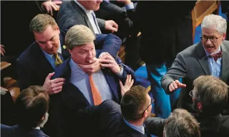  ?? ANDREW HARNIK/AP ?? Rep. Mike Rogers, R-Ala., center, is pulled away by a Republican colleague during a late-night House speaker vote Jan. 6.