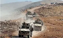  ?? PHOTO: REUTERS ?? A convoy of armoured vehicles belonging to internatio­nal coalition troops drive during the operation against Islamic State militants outside the town of Naweran near Mosul.