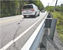  ?? STAFF PHOTO BY TIM BARBER ?? A long crack in the asphalt is visible as southbound traffic passes high above the Tennessee River on Signal Mountain Boulevard on Monday. Efforts are being made to get more repair work done to the busy mountain access road.