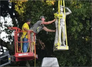  ?? The Associated Press ?? STATUE: The Confederat­e statue located in the Circle at the University of Mississipp­i is lowered to the ground as part of the process to move it to the Confederat­e Soldiers Cemetery on campus, in Oxford, Miss. Tuesday.