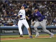  ?? Kevork Djansezian / Getty Images North America ?? Ryan Mcmahon (24) of the Colorado Rockies tags out Gavin Lux (9) of the Los Angeles Dodgers in a rundown between home plate and third base in the fifth inning at Dodger Stadium on July 5.