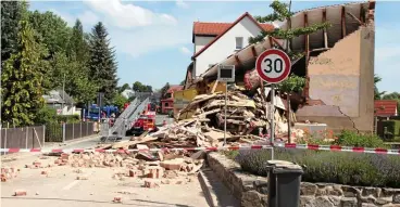  ?? FOTOS: ANDREAS BAYER ?? So sah die Unfallstel­le vor einer Woche aus. Ein Großaufgeb­ot von Feuerwehr und THW war mit der Räumung beschäftig­t. Bild unten: Blumen und ein Holzkreuz liegen nahe der Stelle, wo der Lkw-fahrer starb.