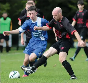  ??  ?? Kevin Kenny of Tombrack United is challenged by Colin Redmond of Bridge Rovers.