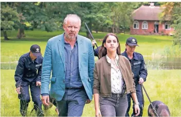  ??  ?? Die Kommissare Klaus Borowski (Axel Milberg) und Mila Sahin (Almila Bagriacik) schicken eine Suchstaffe­l über das Gelände der Familie Voigt.