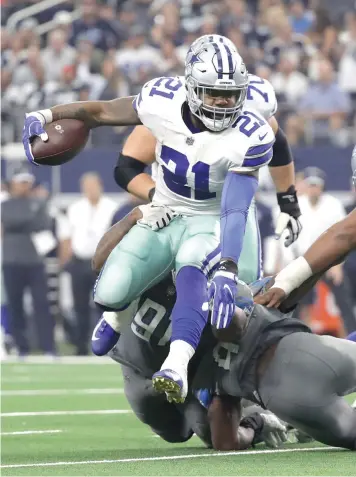  ?? Eric Gay/Associated Press ?? ■ Dallas Cowboys running back Ezekiel Elliott (21) jumps to avoid a tackle by Detroit Lions defensive tackle A'Shawn Robinson, rear, and linebacker Jarrad Davis (40) in the second half of an NFL game Sunday in Arlington, Texas.