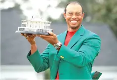  ?? - AFP photo ?? Tiger Woods of the United States celebrates with the Masters Trophy during the Green Jacket Ceremony after winning the Masters at Augusta National Golf Club.