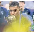  ?? FOTO: AP ?? Kylian Mbappe gibt dem WM-Pokal einen Kuss.