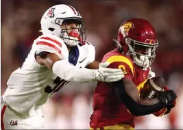  ?? KATELYN MULCAHY — GETTY IMAGES ?? Arizona's Isaiah Ward tackles USC running back MarShawn Lloyd during the second quarter Saturday night at the Coliseum. The game was still in progress when this edition went to press. For details and more on USC football, go to ocregister.com/sports.