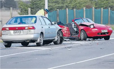  ?? Photo:DEAN KOZANIC/FAIRFAX NZ ?? Crash investigat­ion: Police at the scene of a fatal accident on West Coast Rd yesterday.