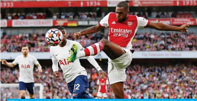  ?? — AFP ?? LONDON: Arsenal’s Portuguese defender Nuno Tavares (right) crosses the ball during the English Premier League football match between Arsenal and Tottenham Hotspur at the Emirates Stadium yesterday.