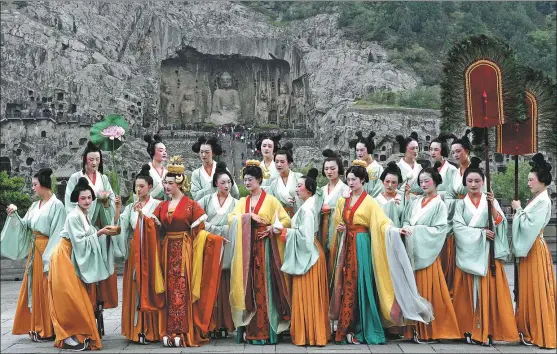  ??  ?? The actresses relive the scene from the classic grotto artwork Emperor and Empress’ Ceremony to the Buddha in the Longmen Grottoes Scenic Area in Luoyang, Central China’s Henan province.