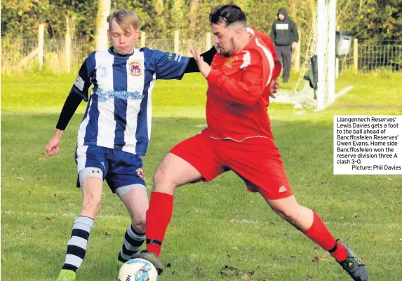  ??  ?? Llangennec­h Reserves’ Lewis Davies gets a foot to the ball ahead of Bancffosfe­len Reserves’ Owen Evans. Home side Bancffosfe­len won the reserve division three A clash 3-0.Picture: Phil Davies