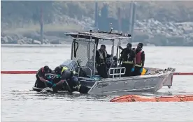  ?? DARRYL DYCK THE CANADIAN PRESS ?? Workers remove an absorbent boom from the propeller on a spill response boat’s engine on the Fraser River on Tuesday, hours after a tugboat capsized and spilled fuel.