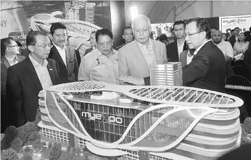  ??  ?? Najib (second right) being briefed by PULSE Group chairman Datuk Seri Hasim Ismail (right) on a model of the MyExpo convention centre during the ground-breaking ceremony. — Bernama photo