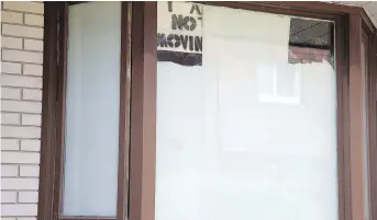  ??  ?? A resident puts up a no moving sign in a front window, left, as the Sept. 30 deadline to move approaches, and community garden planters lay barren, right. Some tenants have vowed not to move on principle. But others have said that they would like Timbercree­k to give them more time to find an adequate place as rental supply is at its peak in the city.